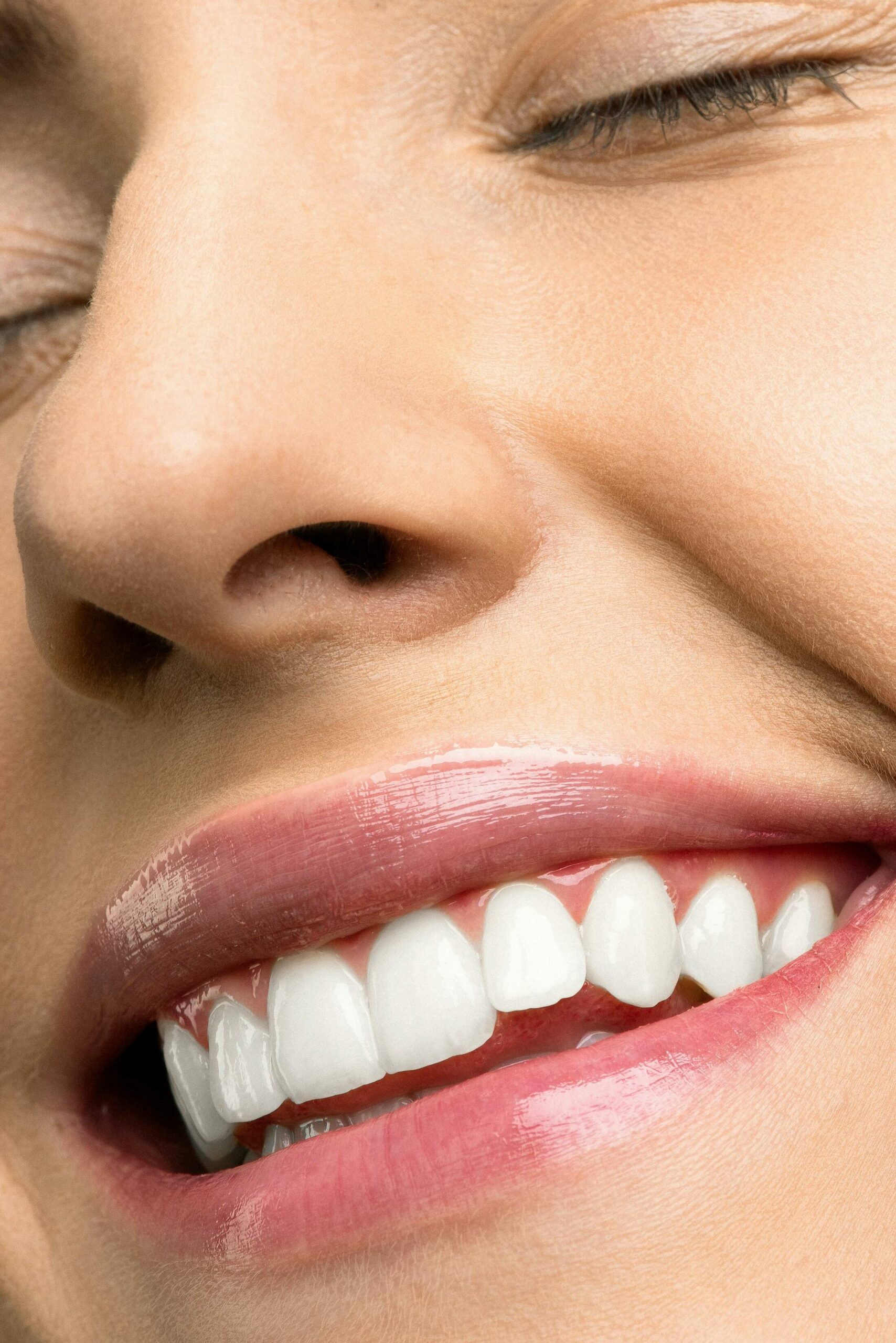 Close-up Photo of Woman With Pink Lipstick Smiling with Her Eyes Closed